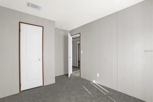a view of an empty room with closet and a window