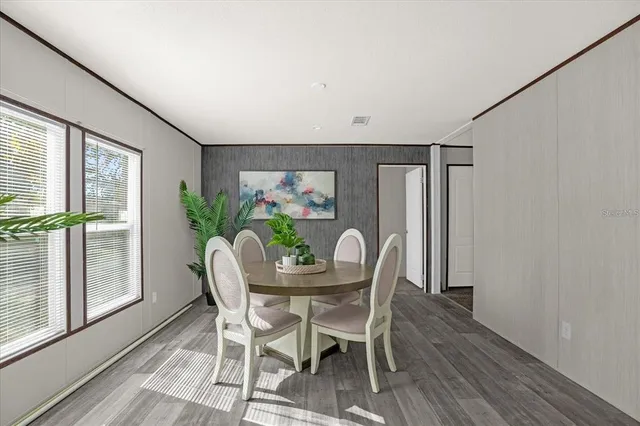 a dining room with furniture a window and a potted plant