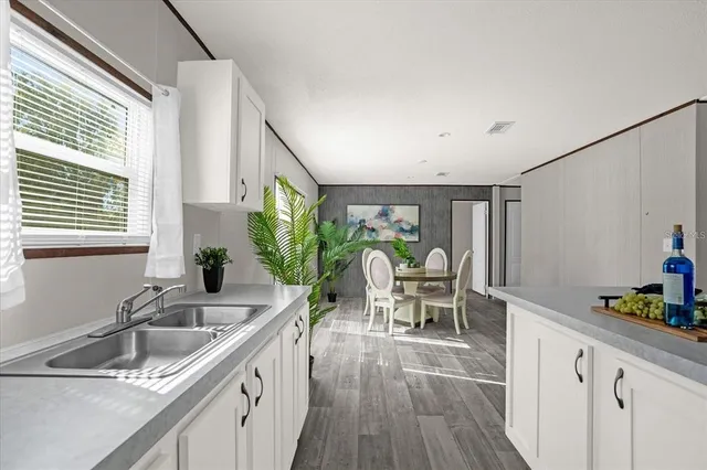 a kitchen that has a sink and chairs