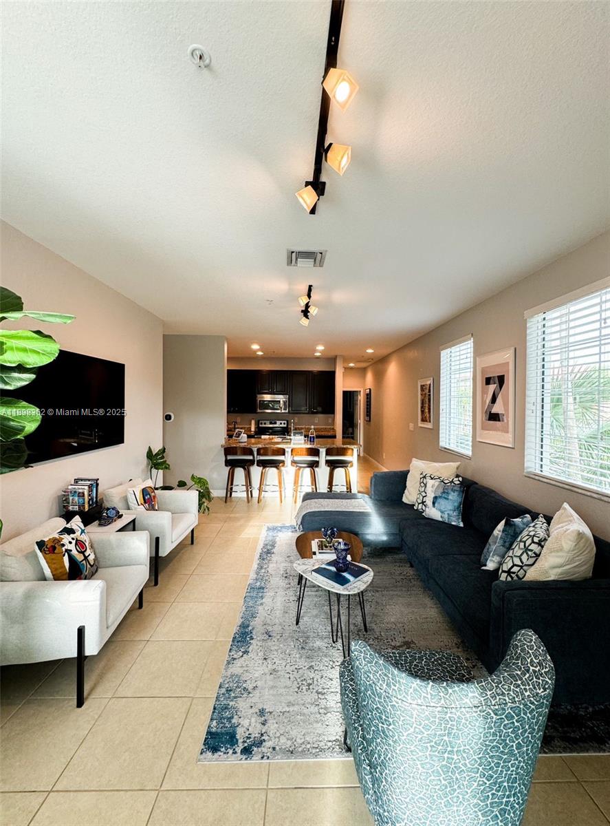 1006 Southwest 147th Avenue, Unit 10601 Pembroke Pines, FL 33027 - Photo 13 of 38 a living room with furniture and a flat screen tv