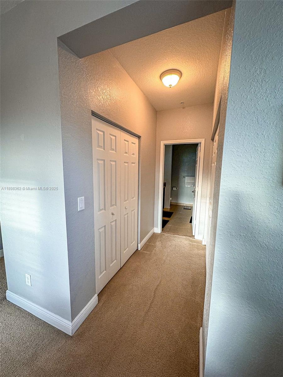 1006 Southwest 147th Avenue, Unit 10601 Pembroke Pines, FL 33027 - Photo 22 of 38 a view of a hallway with wooden shelves