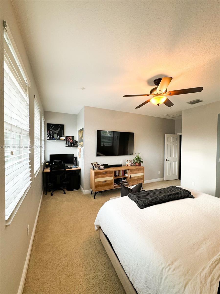 1006 Southwest 147th Avenue, Unit 10601 Pembroke Pines, FL 33027 - Photo 26 of 38 a bedroom with furniture and a flat screen tv