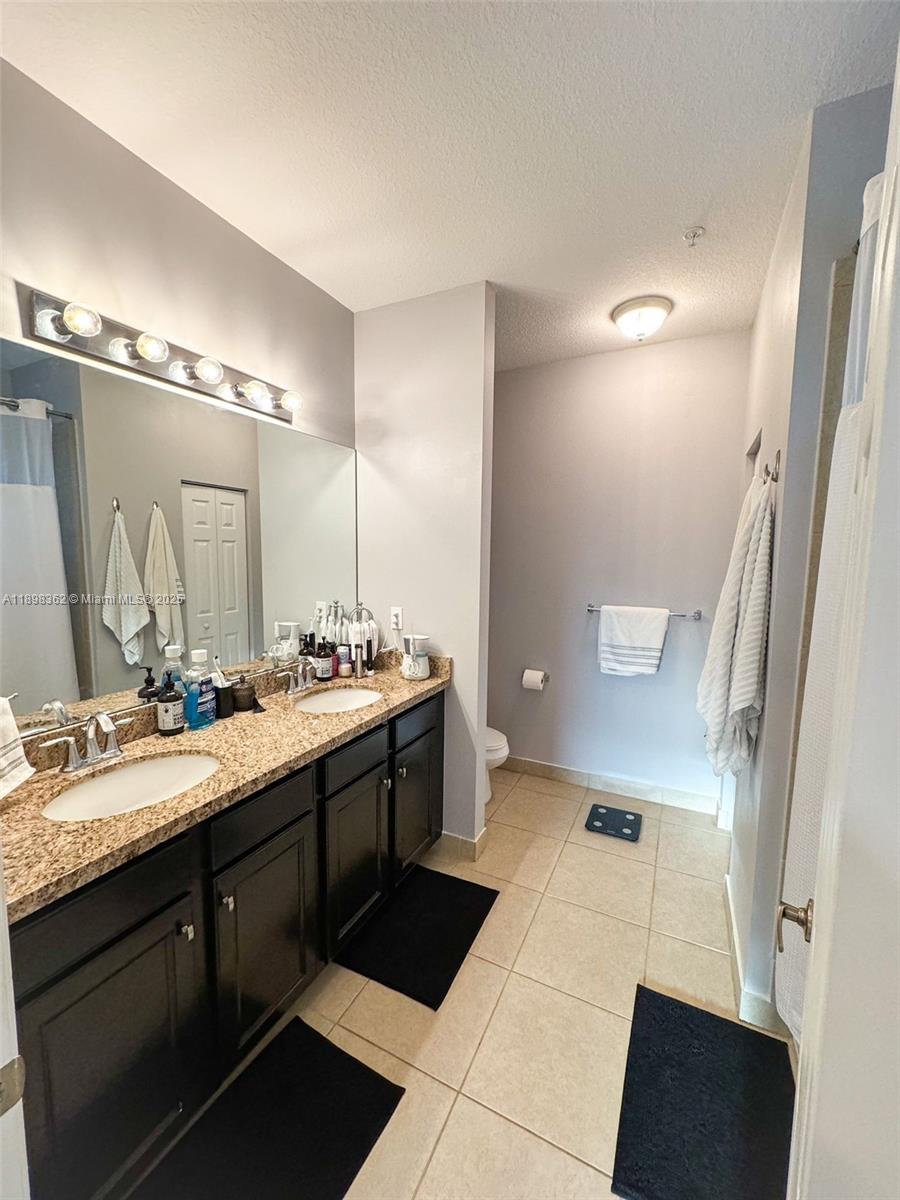1006 Southwest 147th Avenue, Unit 10601 Pembroke Pines, FL 33027 - Photo 27 of 38 a spacious bathroom with a double vanity sink a mirror and a shower