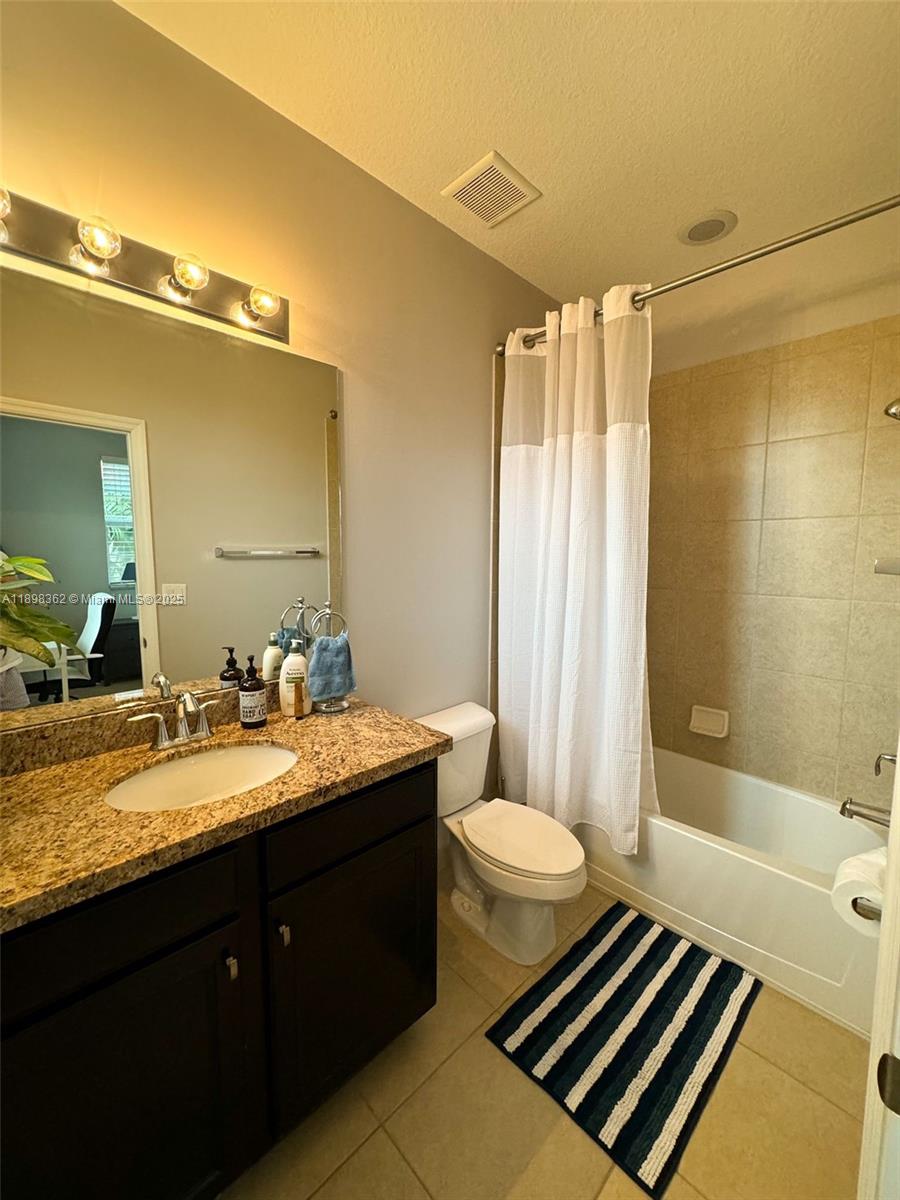 1006 Southwest 147th Avenue, Unit 10601 Pembroke Pines, FL 33027 - Photo 30 of 38 a bathroom with a granite countertop sink toilet a mirror and shower