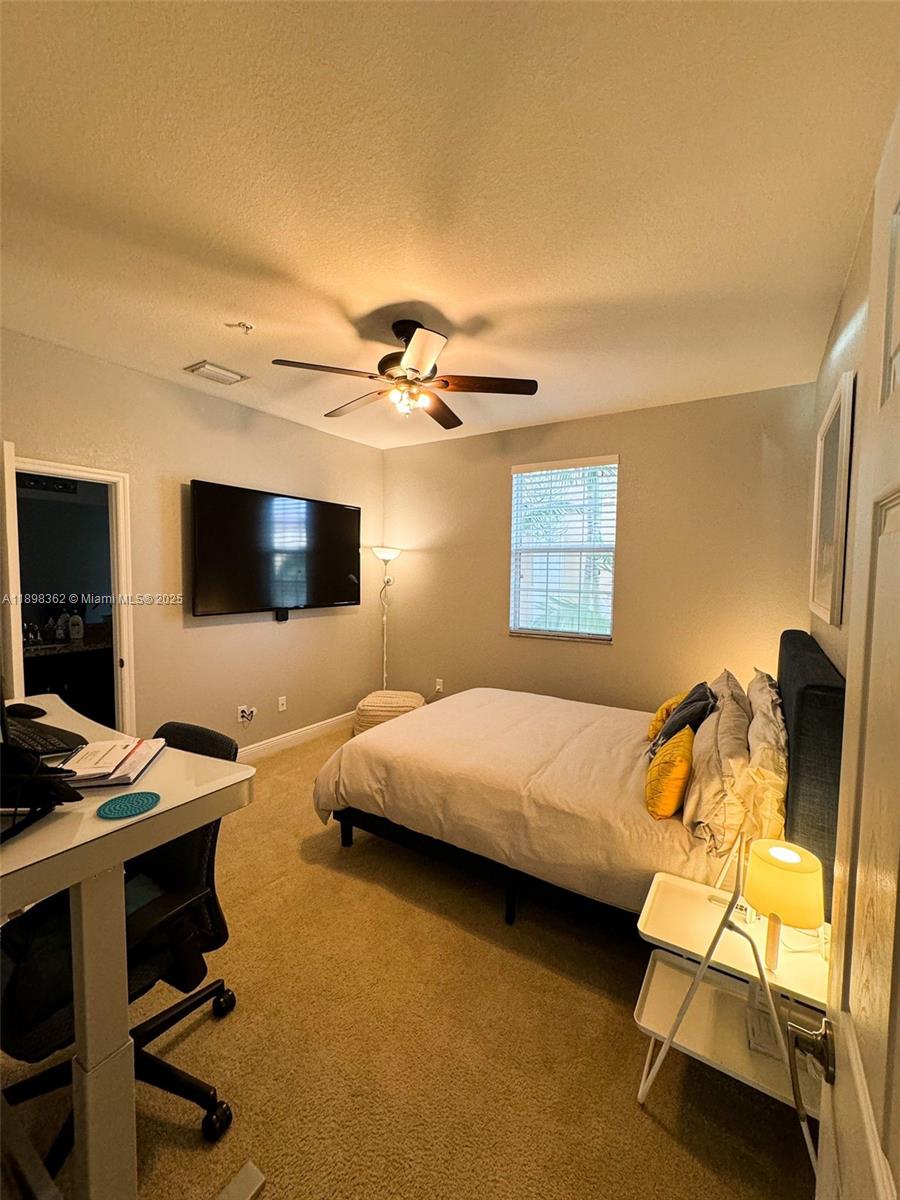 1006 Southwest 147th Avenue, Unit 10601 Pembroke Pines, FL 33027 - Photo 32 of 38 a bedroom with a bed and a flat screen tv