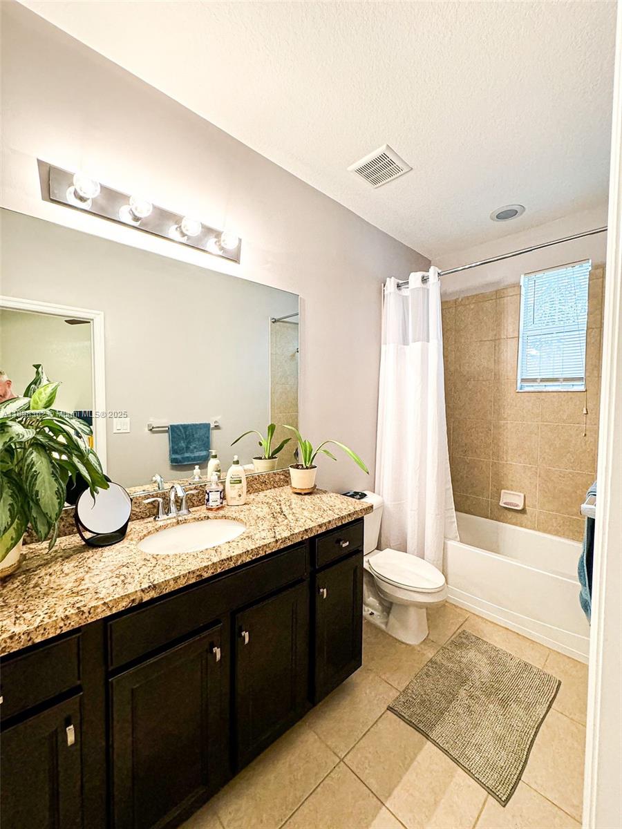 1006 Southwest 147th Avenue, Unit 10601 Pembroke Pines, FL 33027 - Photo 34 of 38 a bathroom with a granite countertop sink mirror and a bathtub