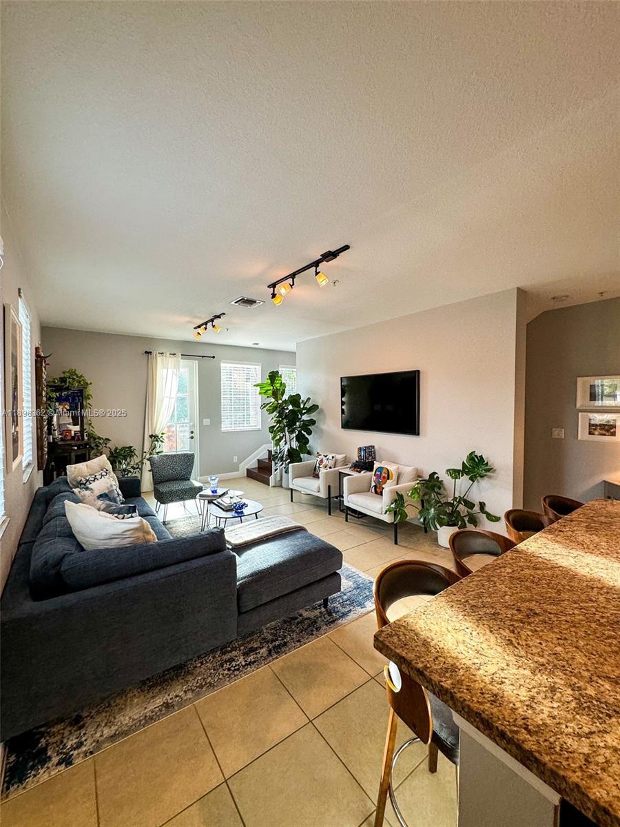 1006 Southwest 147th Avenue, Unit 10601 Pembroke Pines, FL 33027 - Photo 10 of 38 a living room with furniture and a flat screen tv