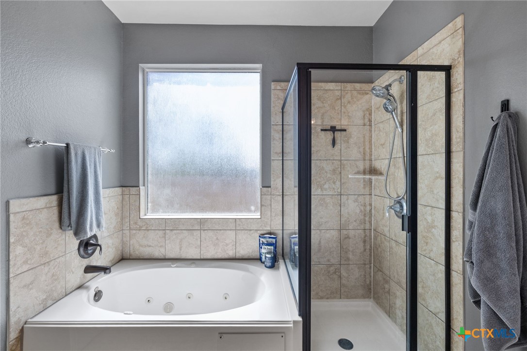 10113 Copper Ridge Cove Austin, TX 78747 - Photo 27 of 32 a bathroom with a bathtub and a shower