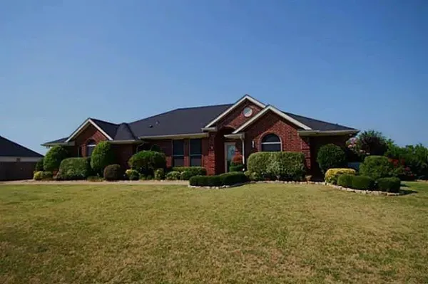 a front view of a house with yard and green space