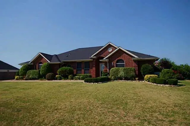 a front view of a house with yard and green space