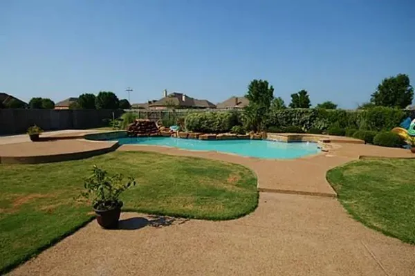 a view of a swimming pool and lounge chairs in the patio