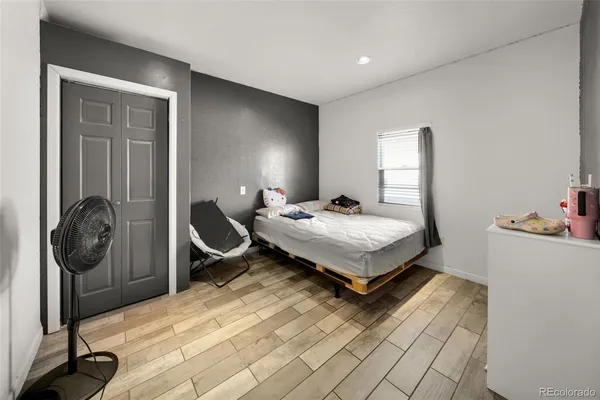 a bedroom with a bed a rug and gym equipment