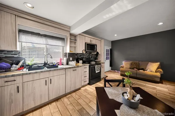 a kitchen with stainless steel appliances kitchen island granite countertop a sink dishwasher stove and white cabinets