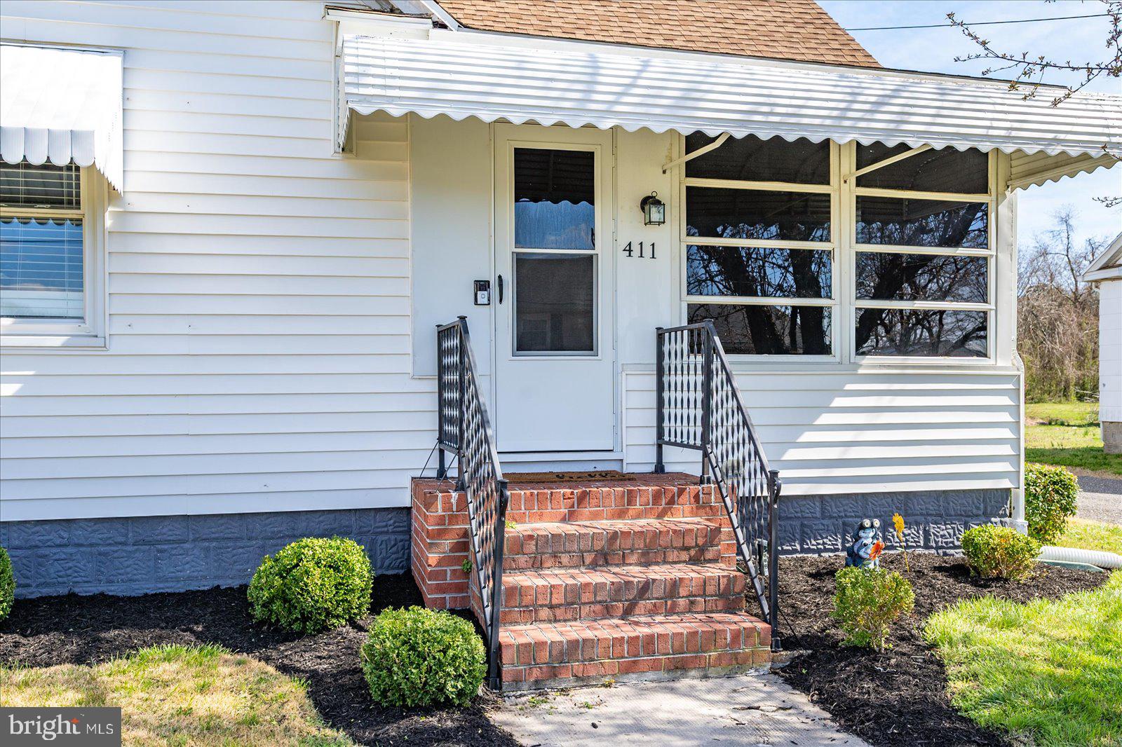 411 East Walnut Street Hebron, MD 21830 - Photo 4 of 54 a front view of a house with a yard and potted plants