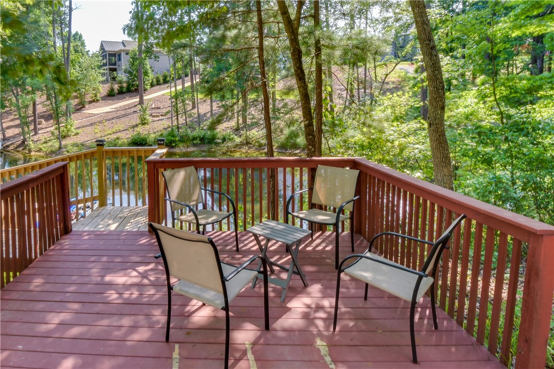 206 Petty Road Seneca, SC 29672 - Photo 8 of 48 A tranquil deck overlooks a serene pond, offering an ideal spot for relaxation and outdoor enjoyment.