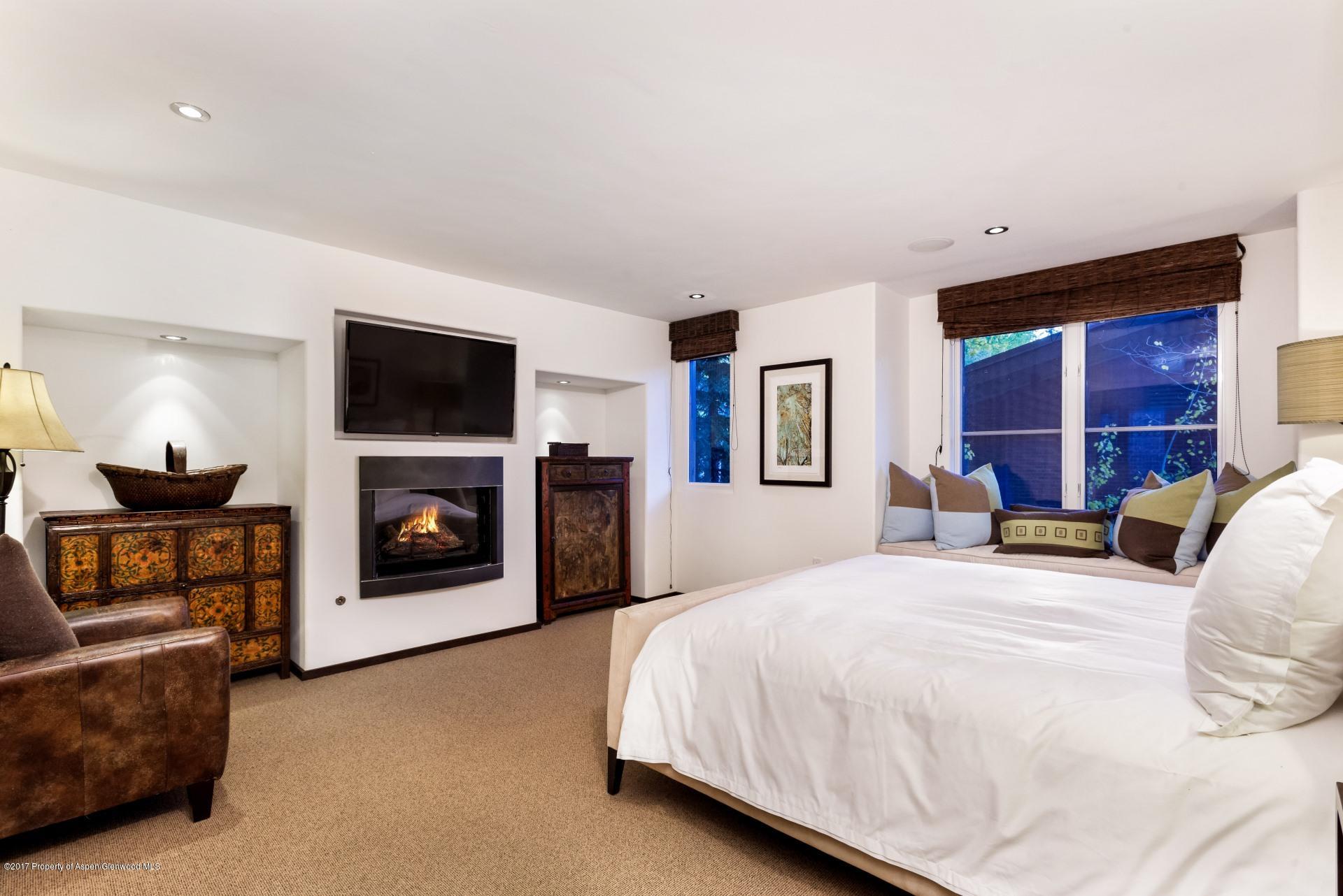 342 Summit Street, Unit B Aspen, CO 81611 - Photo 17 of 31 a bedroom with a bed and a fireplace