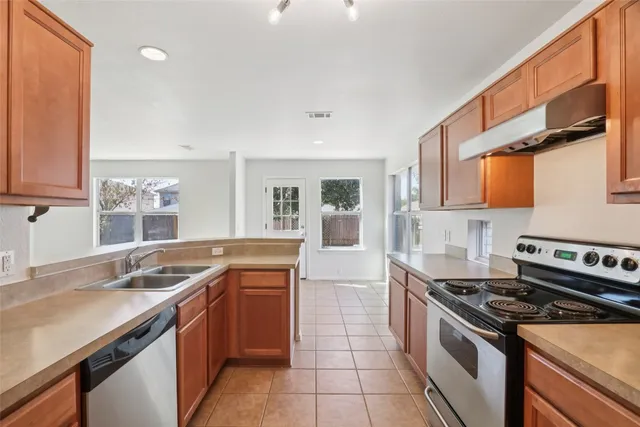a kitchen with stainless steel appliances granite countertop a sink stove and cabinets