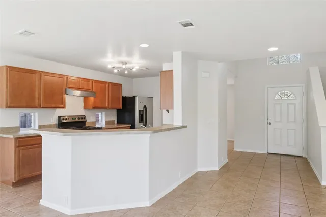 a kitchen with stainless steel appliances granite countertop a refrigerator and a stove top oven