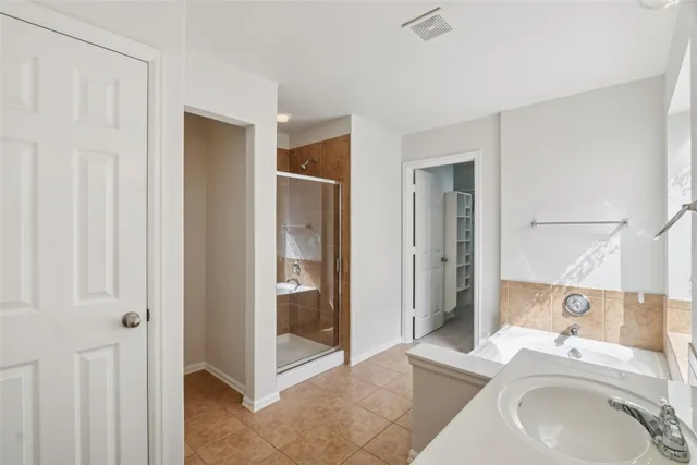a spacious bathroom with a granite countertop sink a mirror and shower