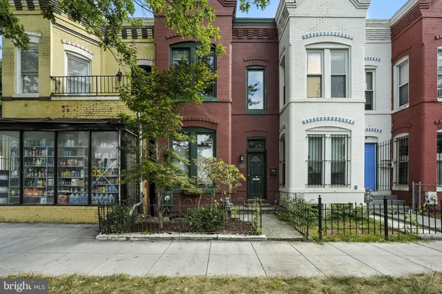front view of a brick house with a yard