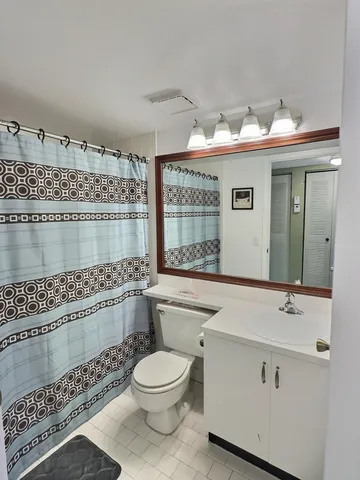 a bathroom with a sink mirror and toilet