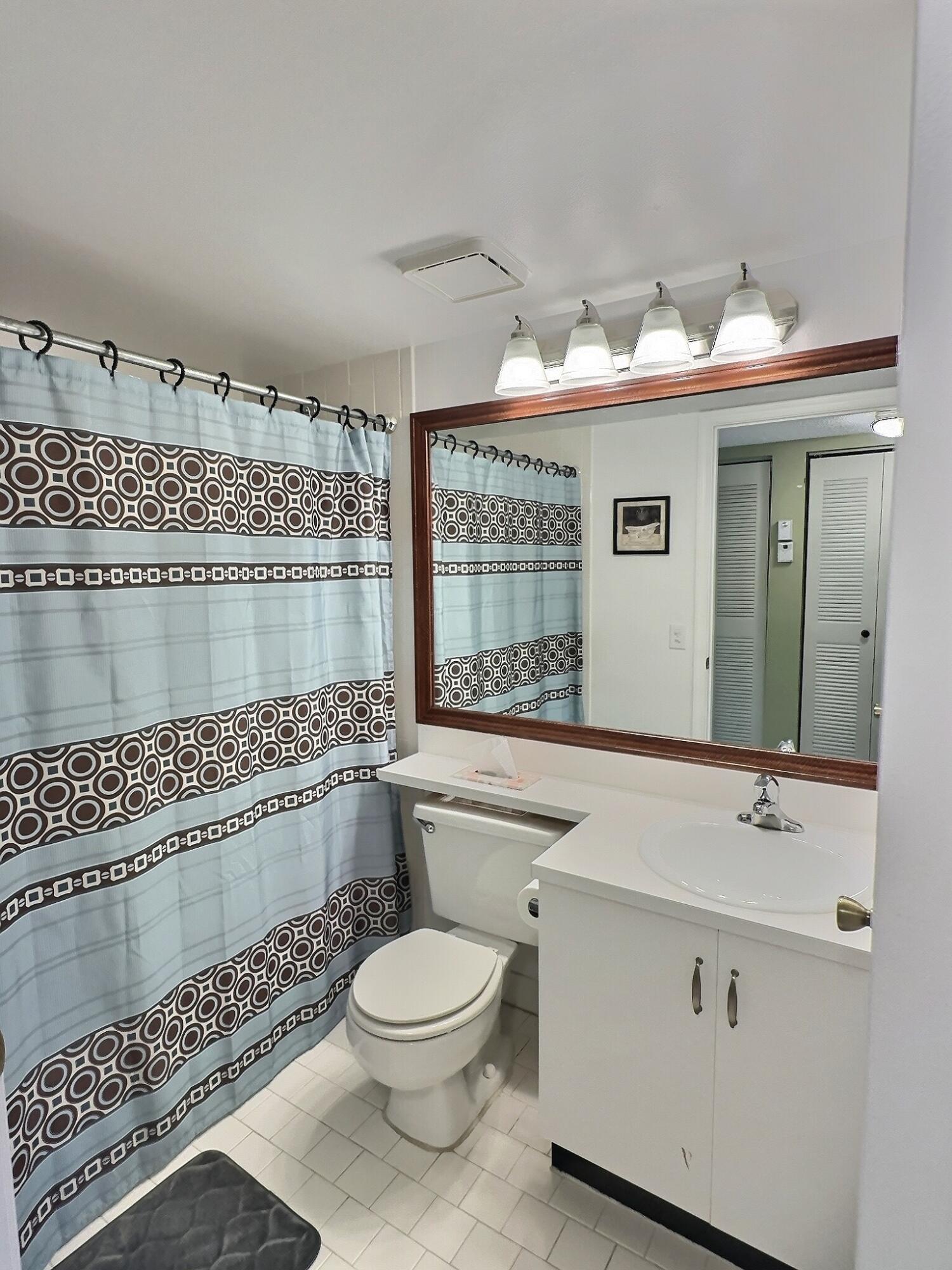 117 Waterside Drive, Unit 117 Hypoluxo, FL 33462 - Photo 11 of 19 a bathroom with a sink mirror and toilet