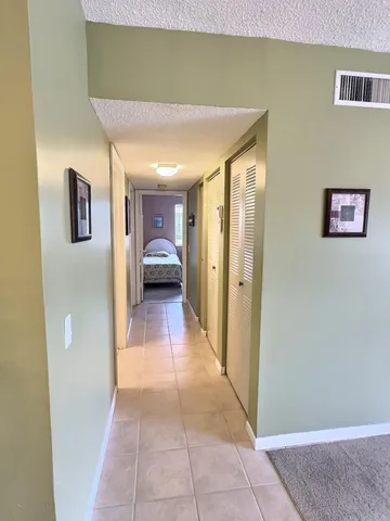 a view of a hallway that has a couch and a view of kitchen