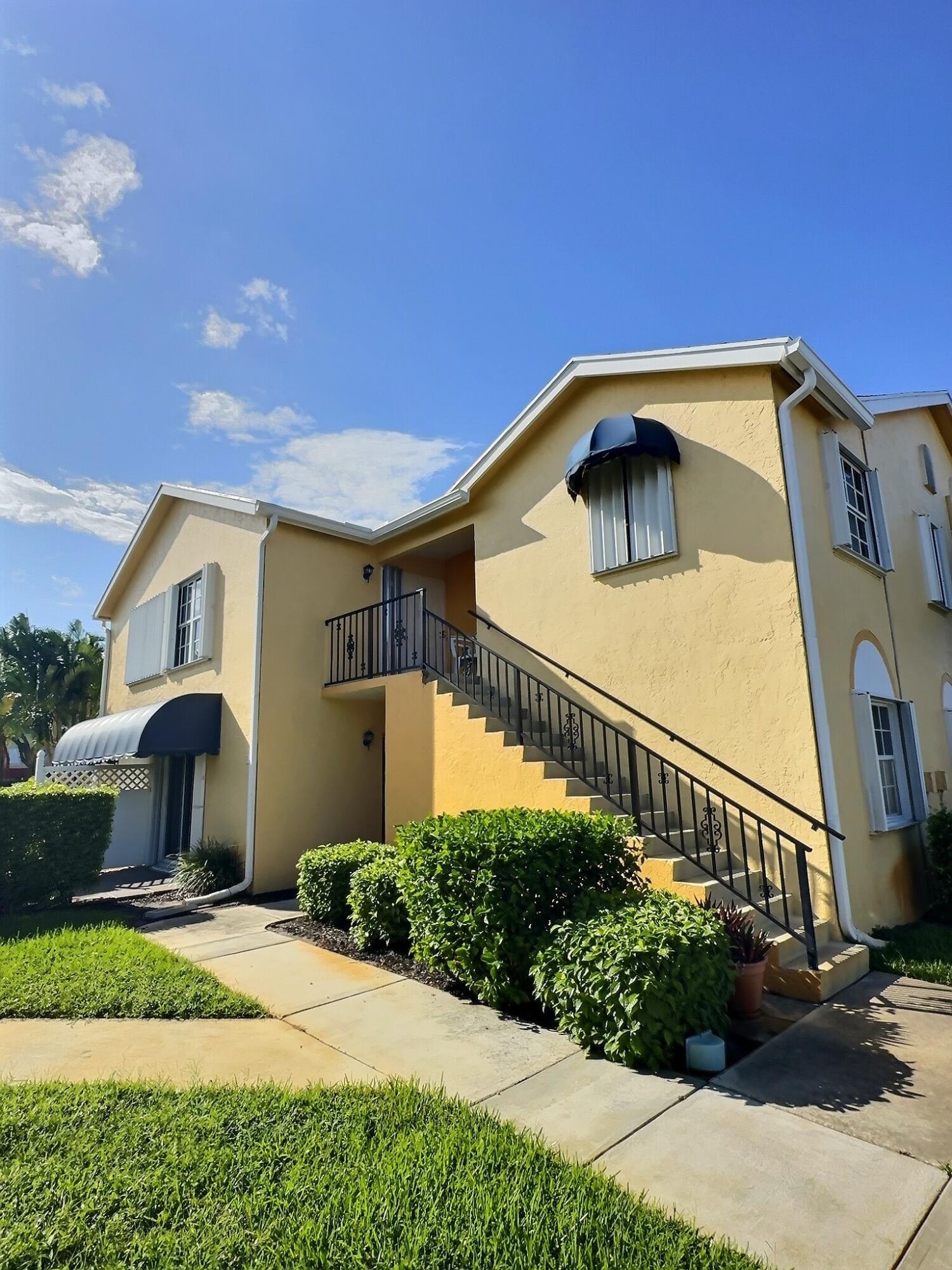117 Waterside Drive, Unit 117 Hypoluxo, FL 33462 - Photo 15 of 19 a front view of a house with a yard