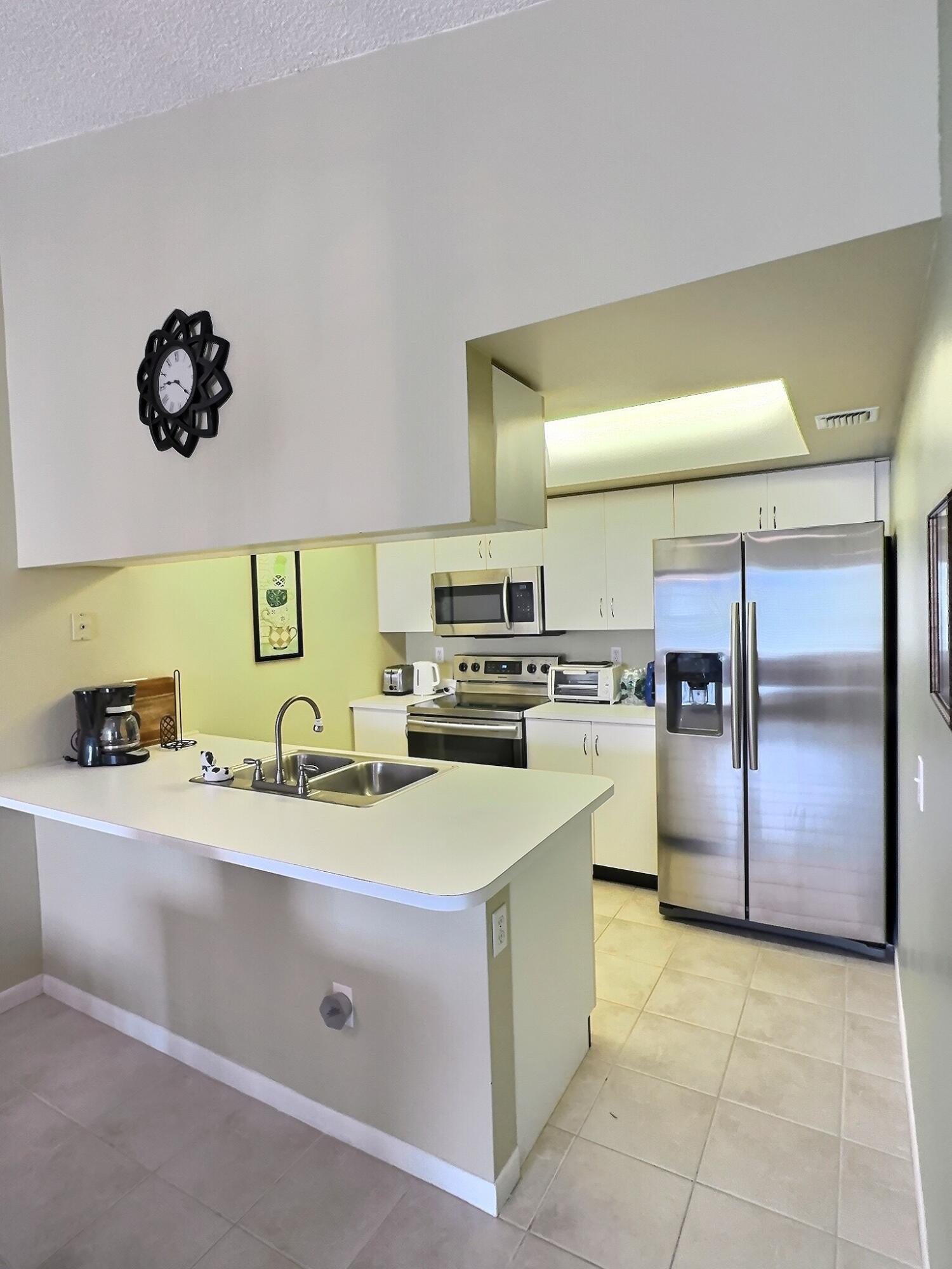 117 Waterside Drive, Unit 117 Hypoluxo, FL 33462 - Photo 6 of 19 a kitchen with a sink appliances and cabinets