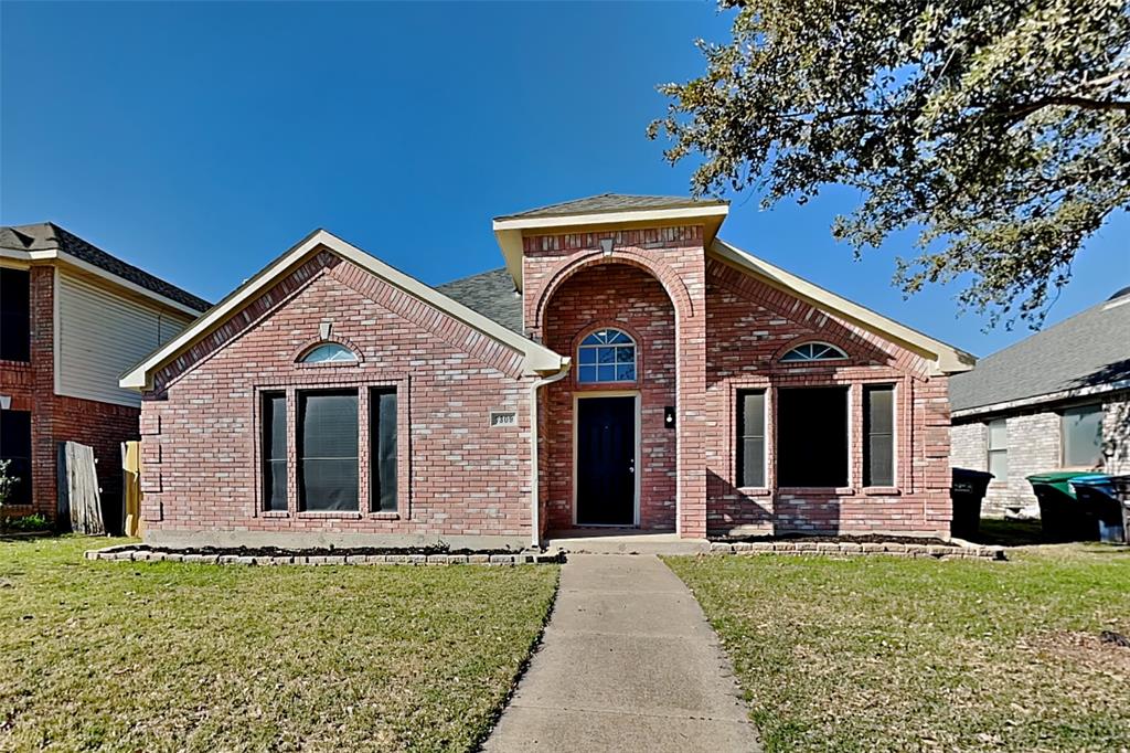 Traditional-style house with a front yard and brick siding