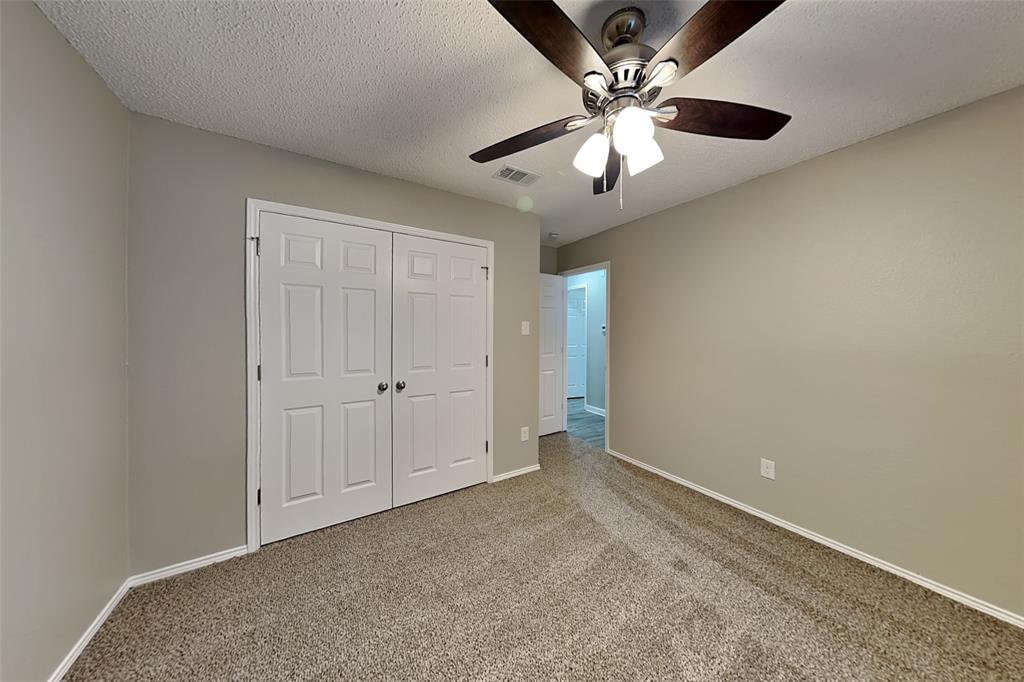 7309 Indiana Avenue Fort Worth, TX 76137 - Photo 12 of 18 Unfurnished bedroom with carpet, a closet, a ceiling fan, and a textured ceiling