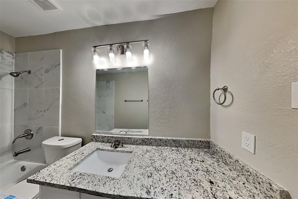 7309 Indiana Avenue Fort Worth, TX 76137 - Photo 14 of 18 Bathroom featuring a textured wall, shower / bathtub combination, and vanity