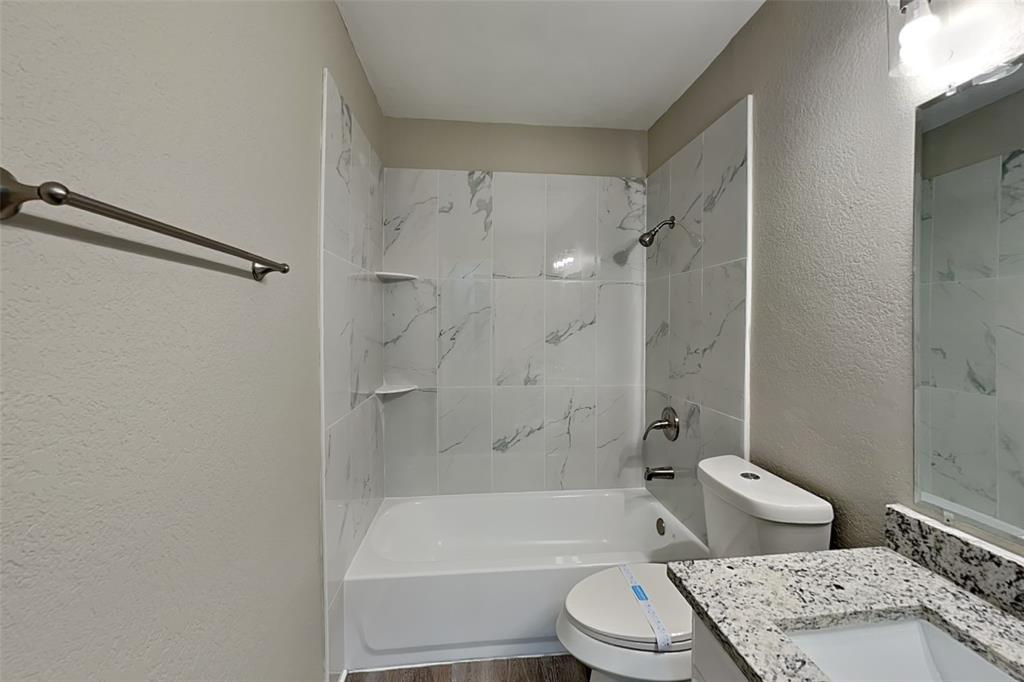 7309 Indiana Avenue Fort Worth, TX 76137 - Photo 15 of 18 Full bathroom featuring a textured wall, vanity, bathing tub / shower combination, and wood finished floors