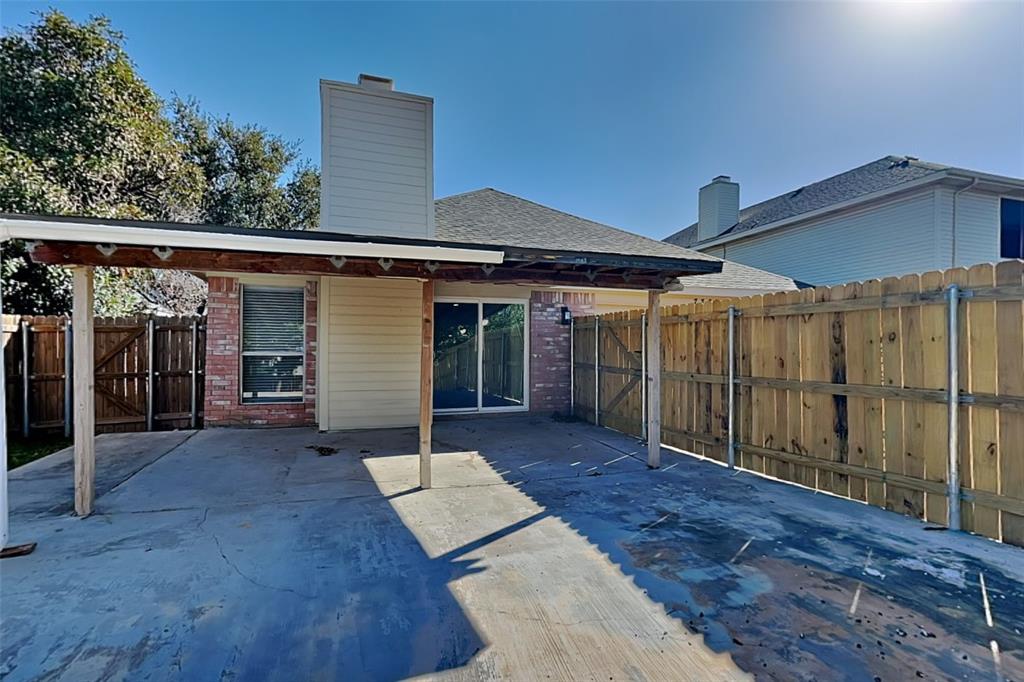7309 Indiana Avenue Fort Worth, TX 76137 - Photo 16 of 18 Back of property featuring a patio area, a fenced backyard, a chimney, roof with shingles, and brick siding