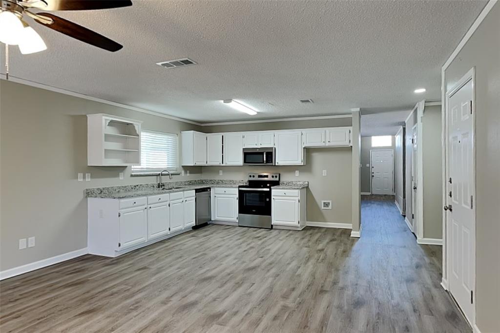 7309 Indiana Avenue Fort Worth, TX 76137 - Photo 5 of 18 Kitchen featuring open shelves, white cabinets, stainless steel appliances, a textured ceiling, and ceiling fan