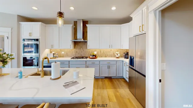 a kitchen with cabinets and wooden floor