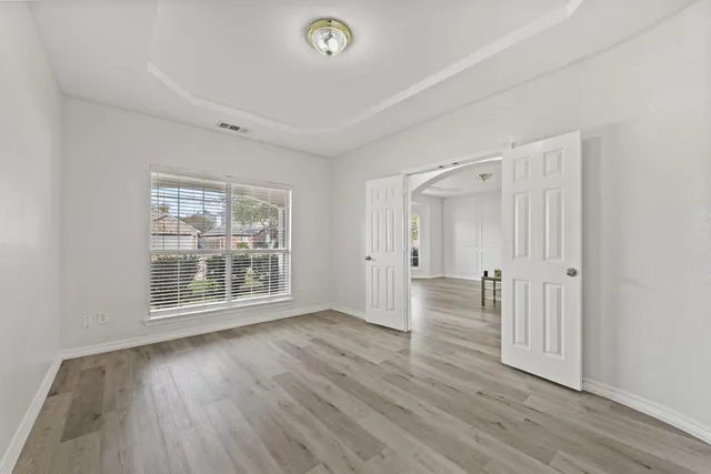 wooden floor in an empty room with a window