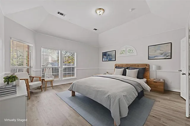 a large bedroom with a bed and large windows