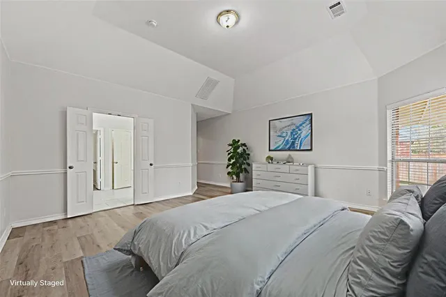 a bedroom with a large bed and a chandelier