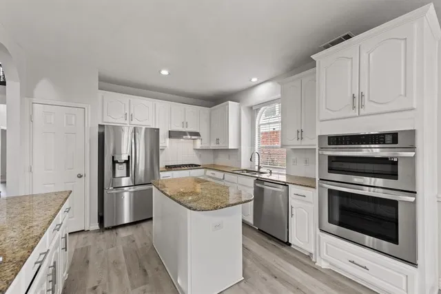 a kitchen with granite countertop stainless steel appliances and wooden cabinets