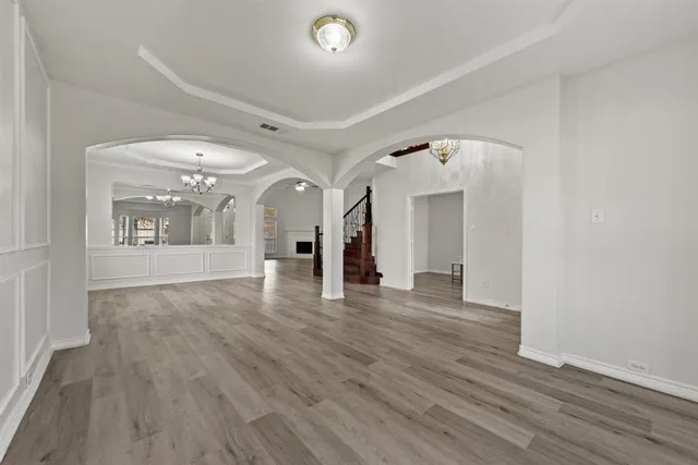 a view of an empty room with wooden floor and a fireplace