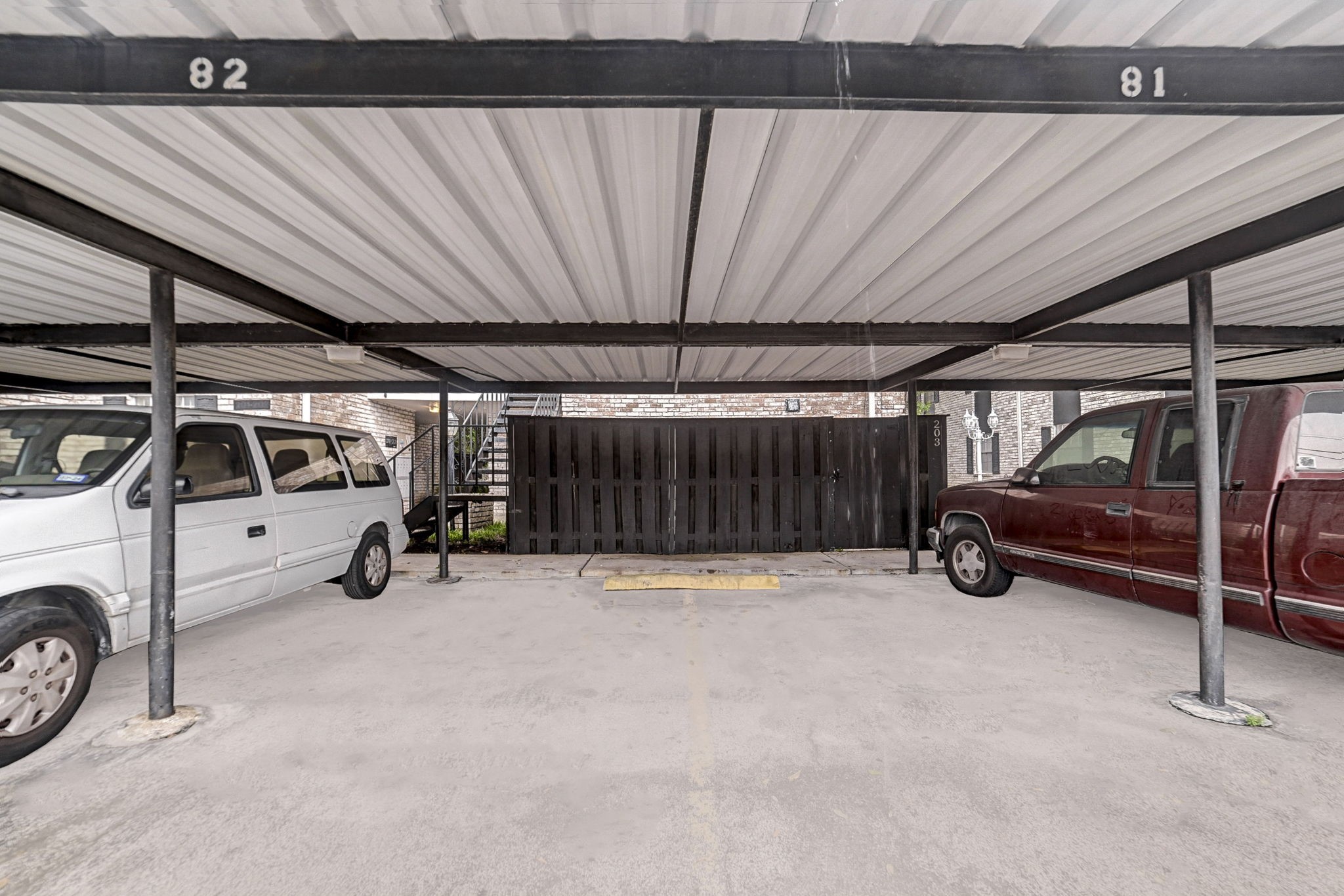 7900 Westheimer Road, Unit 202 Houston, TX 77063 - Photo 24 of 25 Covered parking area with designated spaces provides convenient and sheltered vehicle storage.