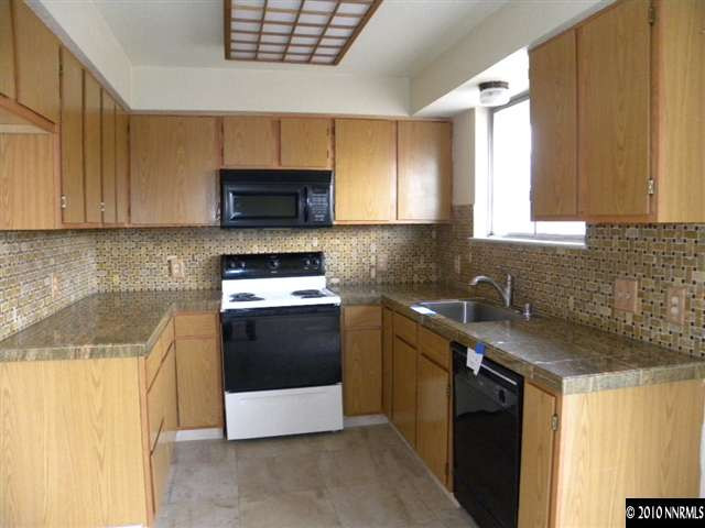 3835 Peregrine Circle Reno, NV 89508 - Photo 4 of 9 a kitchen with granite countertop a sink a stove and cabinets