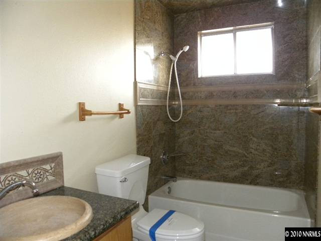 3835 Peregrine Circle Reno, NV 89508 - Photo 6 of 9 a bathroom with a granite countertop bathtub shower sink vanity and toilet