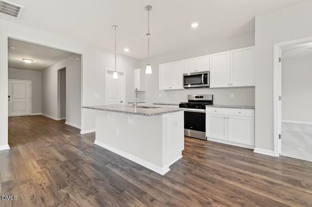 460 Hallingsfield Way Zebulon, NC 27597 - Photo 8 of 31 a kitchen with stainless steel appliances granite countertop a stove a sink and a refrigerator