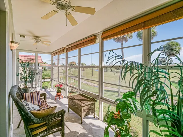 a living room with patio furniture and a potted plant