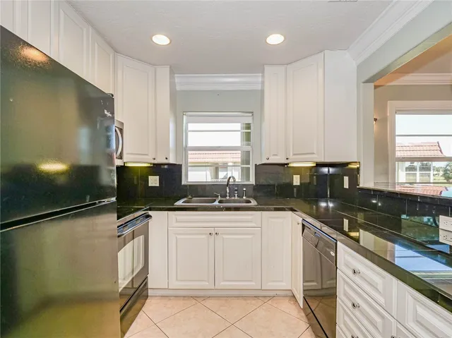 a kitchen with granite countertop a sink stainless steel appliances and cabinets