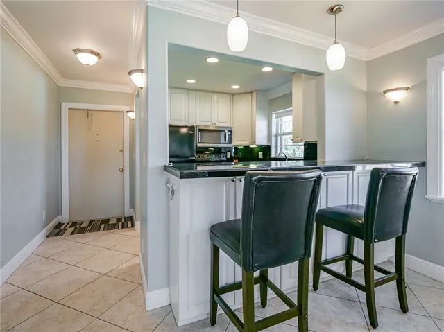 a dining room filled chandelier and kitchen view
