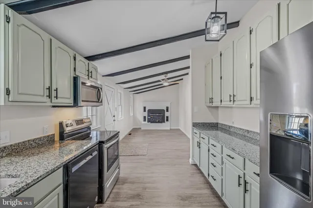 a kitchen with granite countertop a sink stove and refrigerator