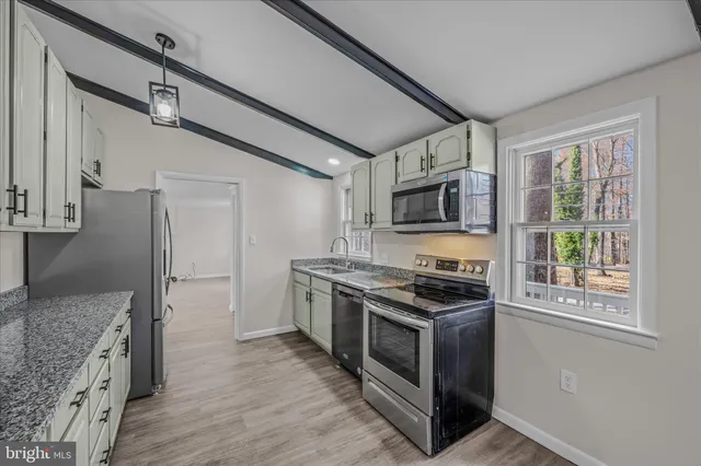 a kitchen with stainless steel appliances granite countertop a stove and a refrigerator